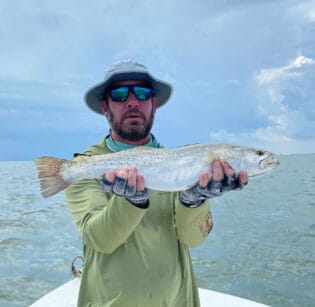 Man holding trout caught on charter