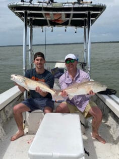 Two anglers holding redfish